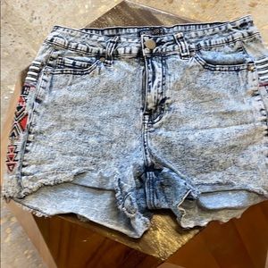 Denim shorts. With tribal symbol on sides.